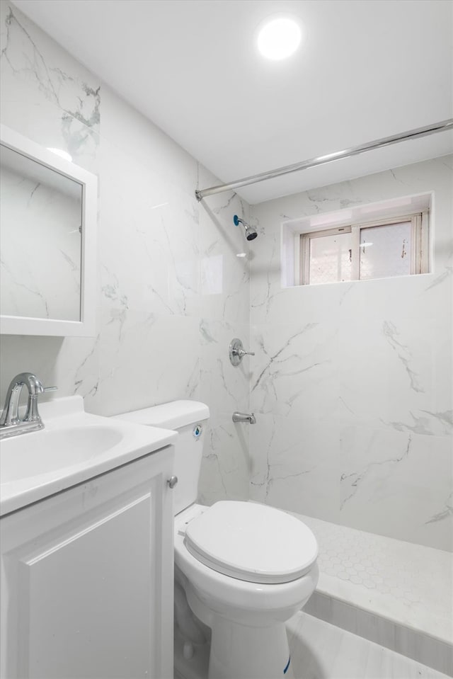 bathroom featuring vanity, toilet, and tiled shower