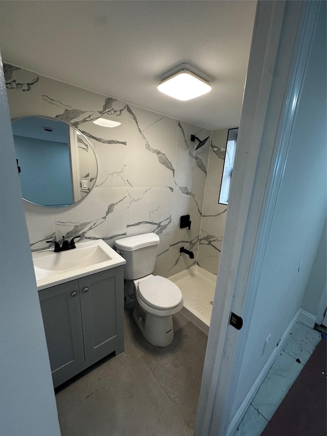 bathroom featuring tiled shower, vanity, tasteful backsplash, and toilet