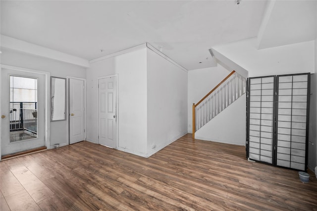 empty room with crown molding and dark hardwood / wood-style flooring