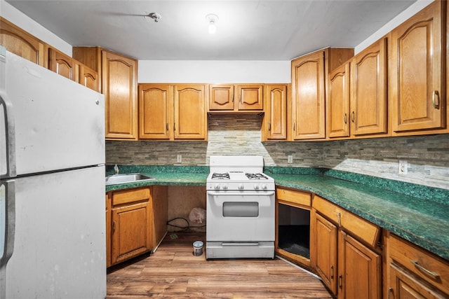 kitchen featuring decorative backsplash, sink, white appliances, and light wood-type flooring