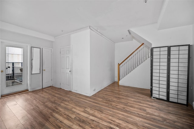 empty room with stairway and wood finished floors