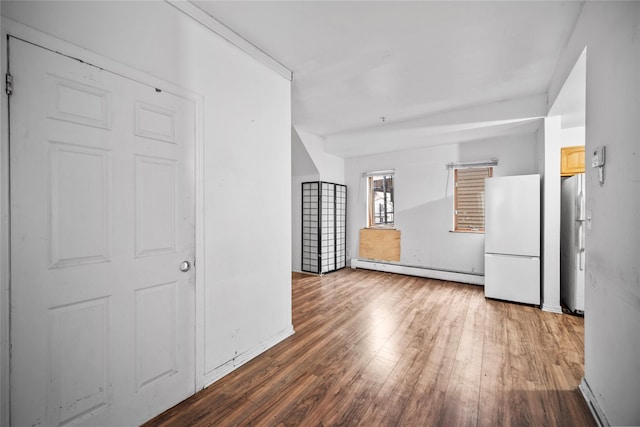 interior space featuring a baseboard heating unit and hardwood / wood-style flooring