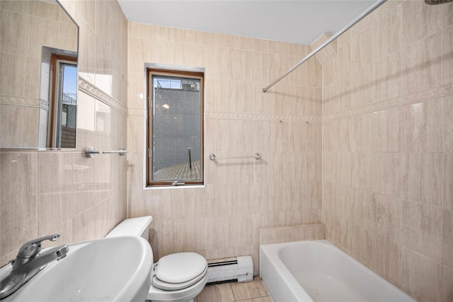 full bathroom featuring a baseboard heating unit, toilet, bathing tub / shower combination, tile walls, and a sink