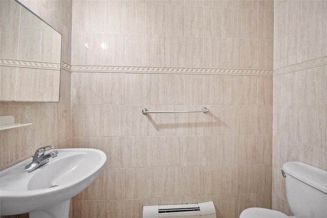 bathroom featuring a sink, toilet, tile walls, and a baseboard radiator