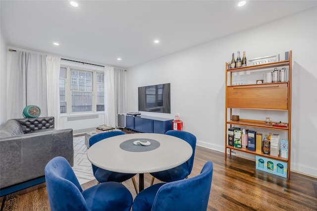 dining area featuring radiator heating unit and dark wood-type flooring