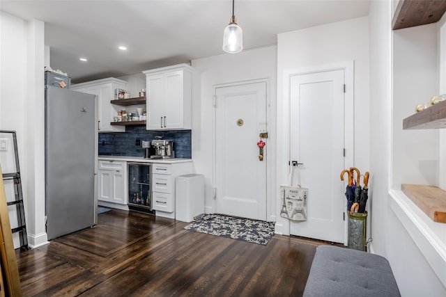 kitchen featuring wine cooler, white cabinetry, stainless steel refrigerator, and tasteful backsplash