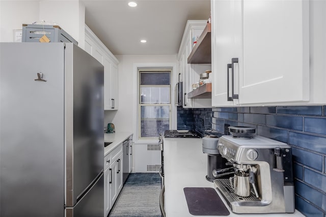 kitchen with white cabinets, decorative backsplash, stainless steel fridge, and radiator heating unit