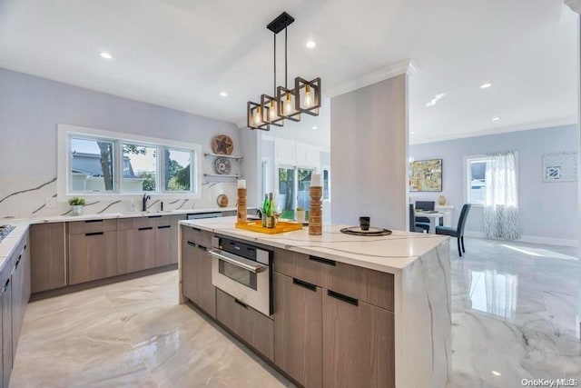 kitchen featuring a wealth of natural light, stainless steel oven, a center island, and decorative light fixtures