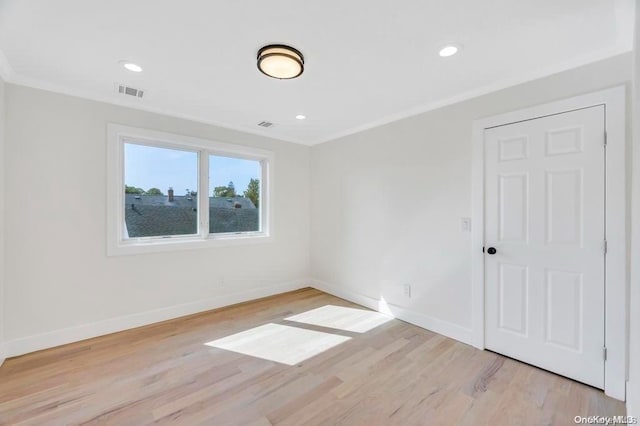 unfurnished room featuring ornamental molding and light wood-type flooring