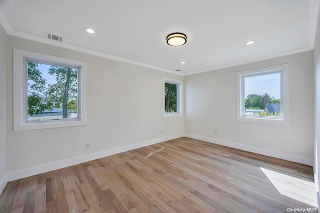 empty room with light hardwood / wood-style floors and ornamental molding