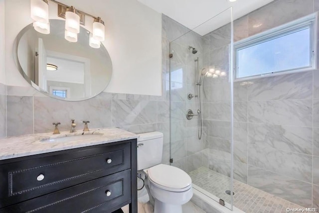 bathroom featuring vanity, toilet, tile walls, and walk in shower