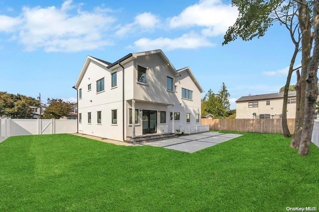 rear view of property featuring a lawn and a patio area