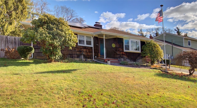 view of front of house featuring a front yard and solar panels