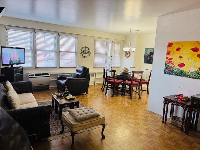 living room featuring light parquet flooring, radiator, and a notable chandelier