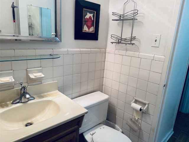 bathroom with vanity, toilet, and tile walls