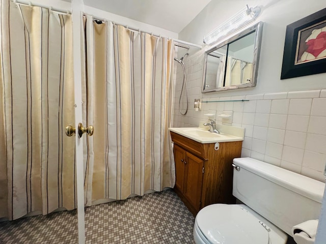 bathroom with walk in shower, tile patterned flooring, toilet, vanity, and tile walls