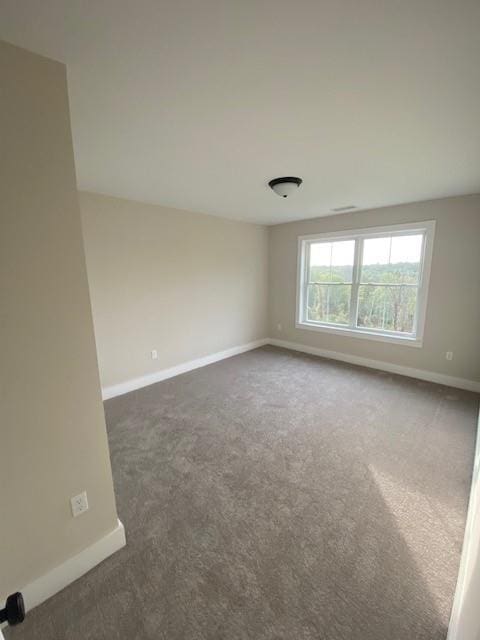 spare room with dark carpet