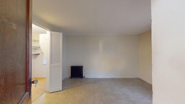 unfurnished room with radiator heating unit