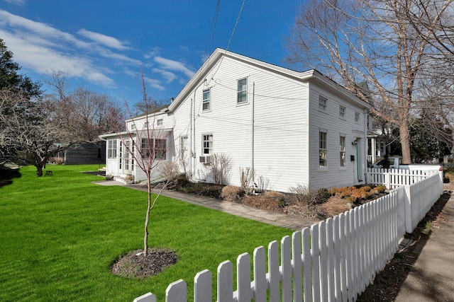 view of side of property featuring a lawn and fence