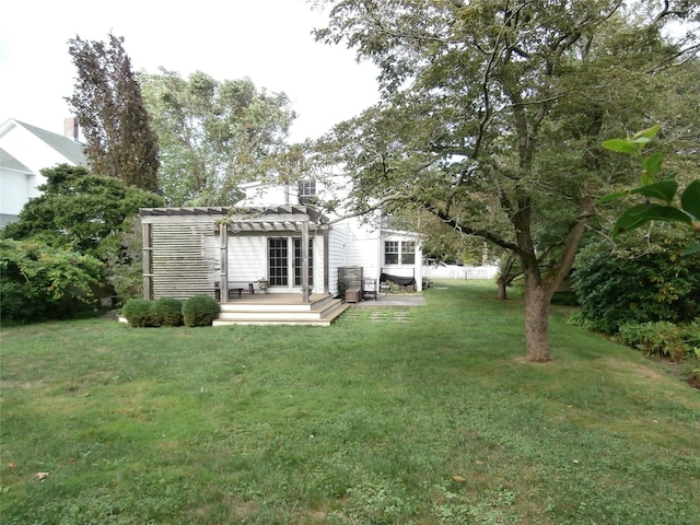 rear view of house with a yard, a wooden deck, and a pergola