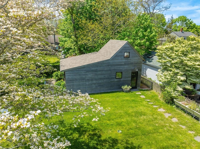 view of home's exterior with a yard and fence