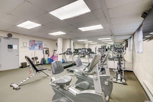 workout area with a drop ceiling and a baseboard heating unit