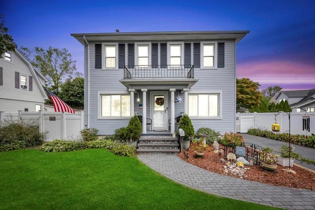 view of front of house featuring a yard and a balcony