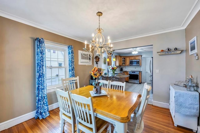 dining area with a wall unit AC, ornamental molding, ceiling fan with notable chandelier, and light wood-type flooring