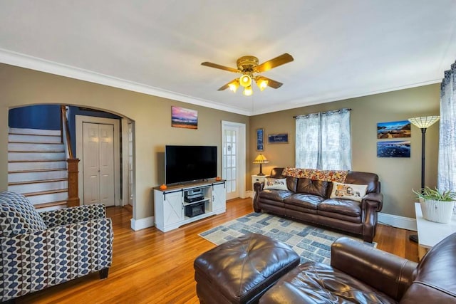 living room with light wood-type flooring, ceiling fan, and ornamental molding