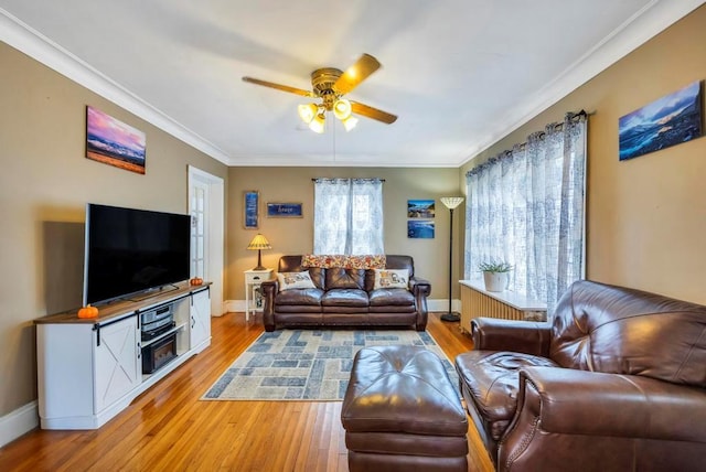 living room featuring light wood-type flooring, ceiling fan, and ornamental molding