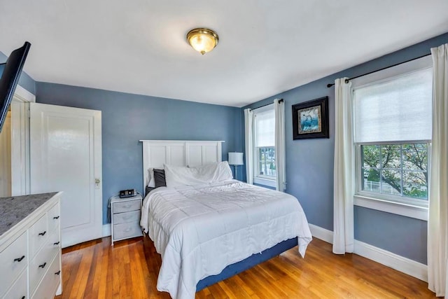 bedroom with hardwood / wood-style flooring and multiple windows