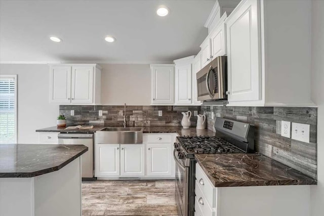 kitchen featuring decorative backsplash, sink, white cabinets, and appliances with stainless steel finishes