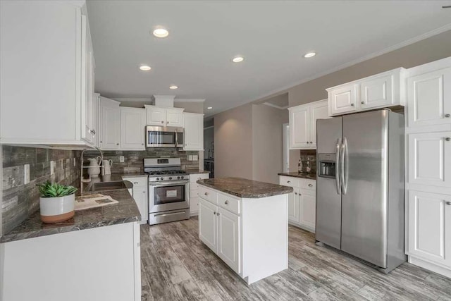 kitchen featuring a center island, white cabinets, stainless steel appliances, and light wood-type flooring