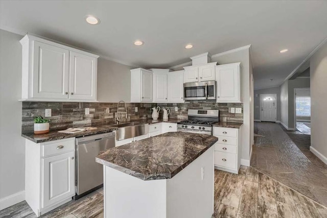 kitchen featuring white cabinets, a center island, stainless steel appliances, and sink