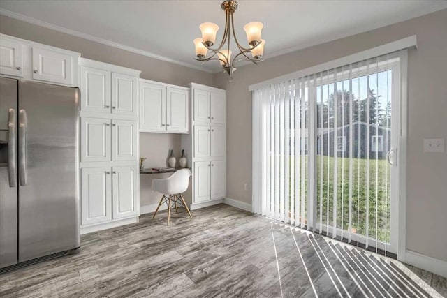 kitchen with white cabinets, plenty of natural light, stainless steel fridge, and crown molding