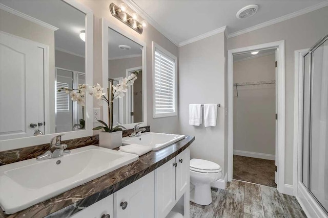 bathroom with crown molding, wood-type flooring, an enclosed shower, toilet, and vanity