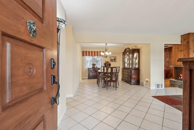 entryway with light tile patterned floors and a chandelier