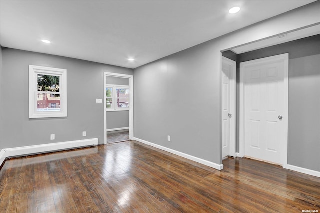 spare room featuring dark hardwood / wood-style flooring and baseboard heating