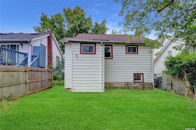 rear view of house featuring a yard