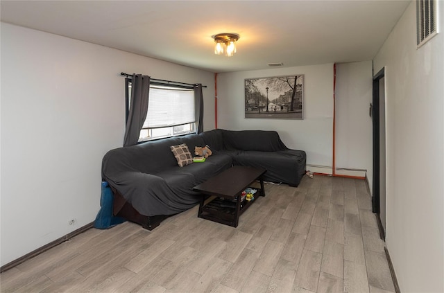 living room with light wood-type flooring and baseboard heating