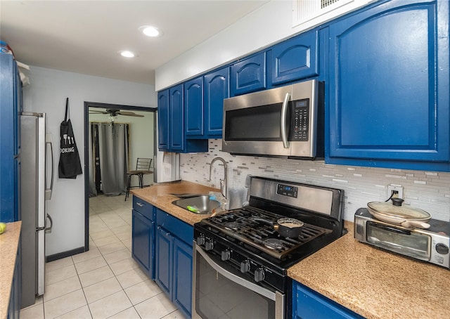 kitchen with ceiling fan, sink, blue cabinets, light tile patterned floors, and appliances with stainless steel finishes