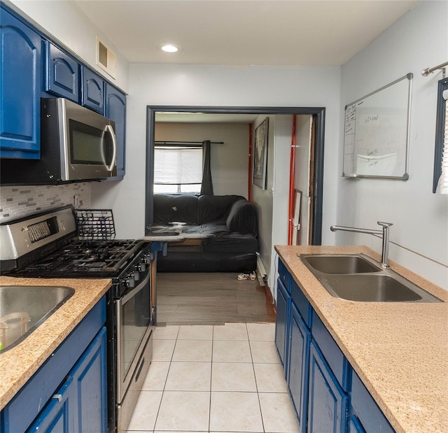 kitchen with light hardwood / wood-style floors, sink, blue cabinets, and stainless steel appliances