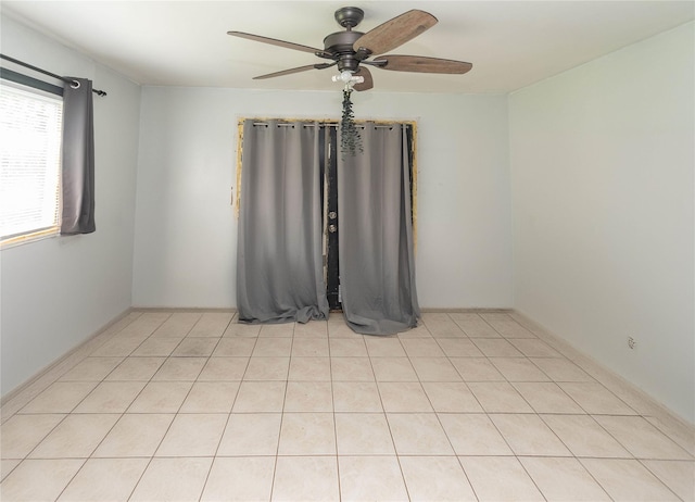 spare room featuring light tile patterned floors and ceiling fan