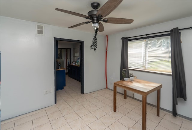 tiled spare room with ceiling fan