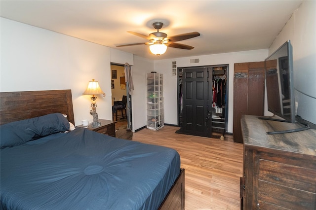 bedroom with a closet, light hardwood / wood-style flooring, and ceiling fan