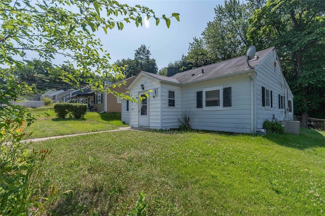 back of property featuring a lawn and central air condition unit