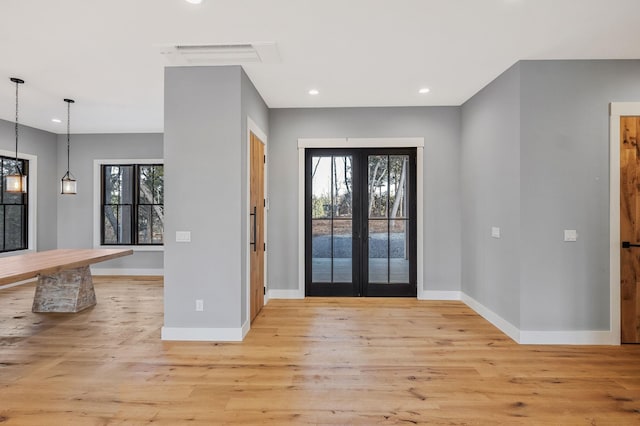 entrance foyer featuring a wealth of natural light, french doors, and light hardwood / wood-style floors