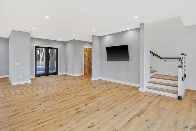 unfurnished living room with french doors and light hardwood / wood-style floors