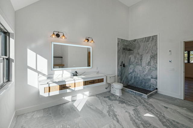 bathroom with vanity, toilet, walk in shower, and a high ceiling