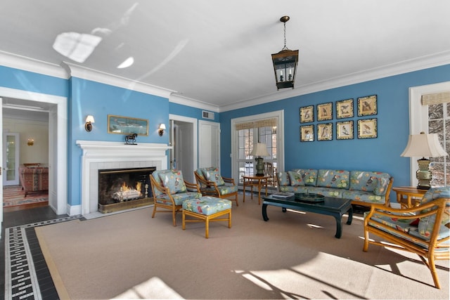 carpeted living room featuring crown molding and a tile fireplace